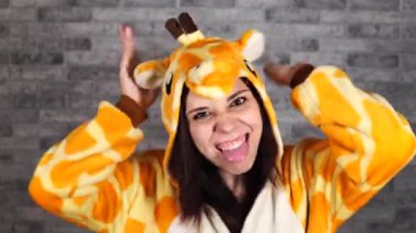 Zürafa şeklinde pijama. Gri tuğlalı arka planda bir kadının duygusal portresi. Takım elbiseli çılgın ve komik bir adam. Çocuk partileri için animatör. Cadılar Bayramı partisi kostümü