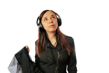 Kulaklıklı güzel bir genç kadın beyaz arka planda yalnız dans ediyor. Uluslararası Müzik Günü konsepti.