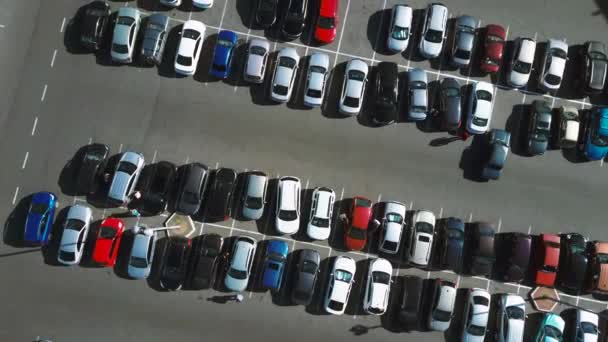 Ein Blick von oben auf den Prozess des Parkens. Starker Verkehr auf dem Parkplatz. Auf der Suche nach Stellplätzen auf dem stark frequentierten Parkplatz. Parkplatzberatung. Parkplatzsuche im belebten Geschäftszentrum — Stockvideo