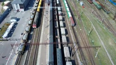 Şehir kargo terminalinde yük trenleri. Tren parkında demiryolları. Işınlama lojistik arka planı için liman kullanımında yük treni konteynırına sahip kargo treni platformu.