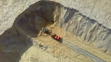 Bir kamyona kum yüklemehavadan görünümü. Bir ağır makine - ekskavatör ve kamyon kum ocağında çalışıyoruz.