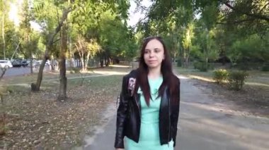  Sırt çantalı genç bir kadın şehirde yürüyor. 