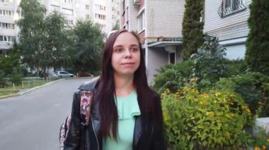  Sırt çantalı genç bir kadın şehirde yürüyor. 