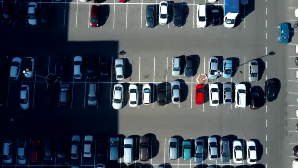Una vista desde arriba al proceso de aparcamiento. Hay mucho tráfico en el estacionamiento. Buscando espacios en el ajetreado aparcamiento. Consejos de estacionamiento. Crucero para estacionamiento en el centro de negocios ocupado — Vídeo de stock