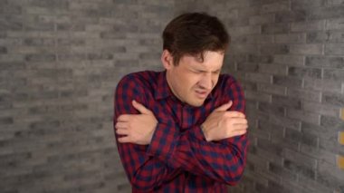 Ekose gömlekli güzel duygusal bir adam onun kulağına el ele tutuşuyor ve gri tuğladan bir arka planda yapılan konuşmaya kulak misafiri olmaya çalışıyor. Meraklı bir erkek geniş bir şekilde gülümsüyor ve birini gözetliyor. Şey...