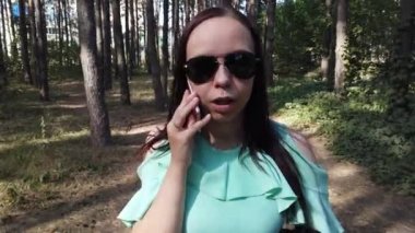 Bahar Ormanı 'nda akıllı telefondan konuşan genç bir kadın 