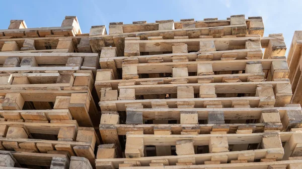 Europalets de madera para transferir mercancías a los clientes. Palets de madera usados apilados en el almacén. Superposición de paletas de madera . — Foto de Stock