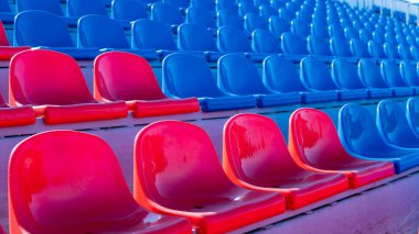 Spor stadyumundaki tribünler. Büyük bir stadyumda kırmızı ve mavi koltuklar.