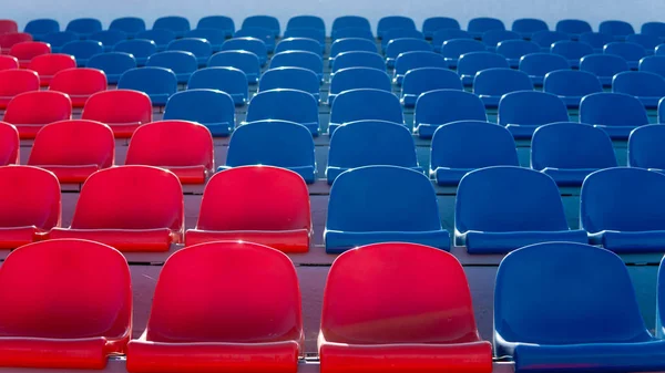 Spor stadyumundaki tribünler. Büyük bir stadyumda kırmızı ve mavi koltuklar.