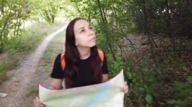 Sırt çantası elinde harita olan bir kadın. Gezgin yalnız seyahat ediyor.