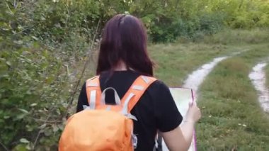 Ormanda haritası olan gezgin bir kadın. Sırt çantalı güzel bir kadının portresi.