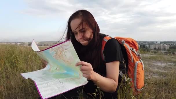 一个带着地图在树林里旅行的女人一个带背包的漂亮女人的肖像 — 图库视频影像