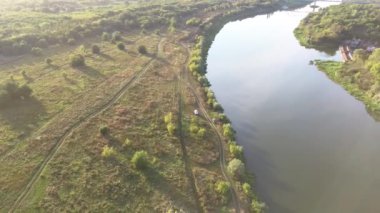 Güneşli bir günde yeşil ormanın arka planına karşı büyük bir nehir.