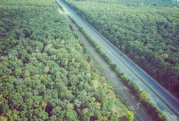 Carros estão se movendo na estrada cercada por árvores verdes no verão. — Fotografia de Stock
