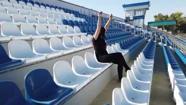 Uma Jovem Roupas Pretas Com Cabelos Longos Está Sentada Estádio — Vídeo de Stock