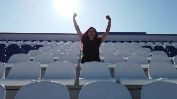 Siyah Elbiseli Uzun Saçlı Genç Bir Kadın Stadyumda Oturuyor — Stok video