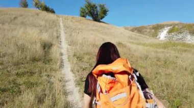 Sırt çantalı genç bayan turist dışarıda yürüyor.