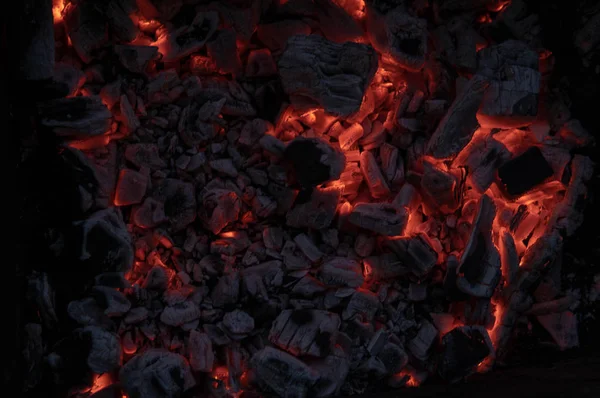 Η υφή της φωτιάς του άνθρακα. Ενεργά σιγανά κάρβουνα φωτιάς. Ιστορικό καψίματος ζεστών κάρβουνων. Ανεμοδαρμένα κάρβουνα τη νύχτα — Φωτογραφία Αρχείου