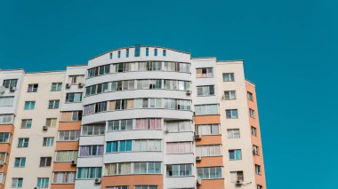 Mavi gökyüzü olan güneşli bir günde modern apartman binaları. Modern bir apartmanın ön cephesi. Modern apartman binası mimarisi