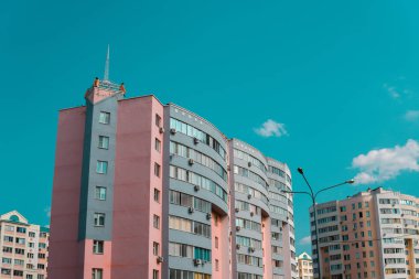 Mavi gökyüzü olan güneşli bir günde modern apartman binaları. Modern bir apartmanın ön cephesi. Modern apartman binası mimarisi