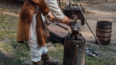 Kıdemli demirci, demircide örsüzerinde erimiş metali taklit etti. Blacksmithing. Çekiç ve örs. Demirci demir ilerler. Köy teknesi. Demirci metal çalışıyor. Workshop.concep'de zanaat için araçlar