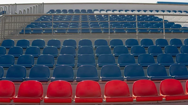 Tribünen in einem Sportstadion. Rote und blaue Sitze in einem großen Straßenstadion. — Stockfoto