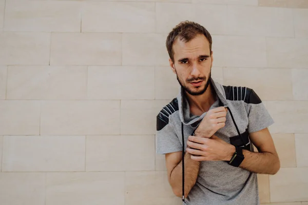 Un retrato de un hombre guapo con barba contra la pared blanca y amarilla.. — Foto de Stock