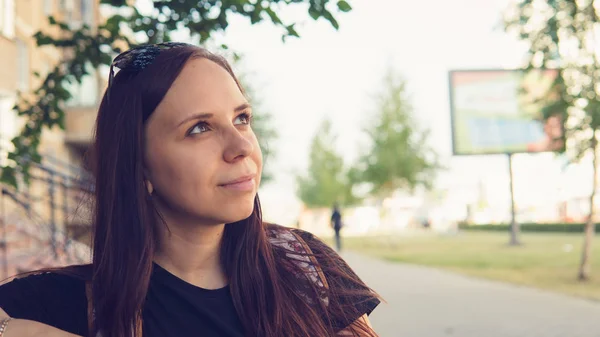 Le portrait d'une belle jeune femme assise sur un banc dans une petite ruelle. — Photo