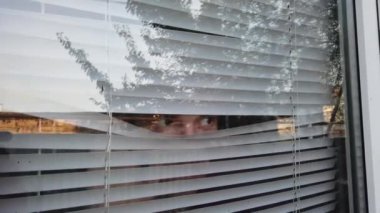 Panjurlardan seçen yakışıklı adam.