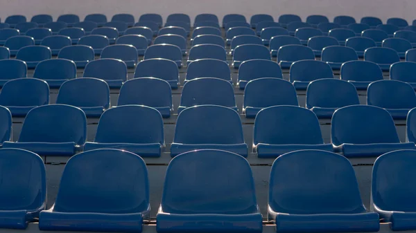 Blanqueadores en un estadio deportivo. Asientos azules en fila — Foto de Stock