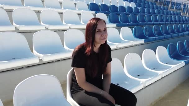 Una Joven Vestida Negro Con Pelo Largo Está Sentada Estadio — Vídeos de Stock