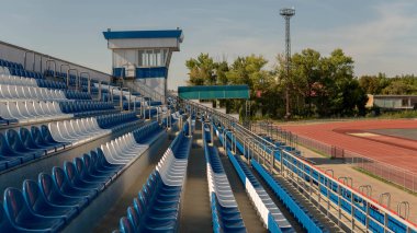 Spor stadyumundaki tribünler. Büyük bir stadyumda kırmızı ve beyaz koltuklar.