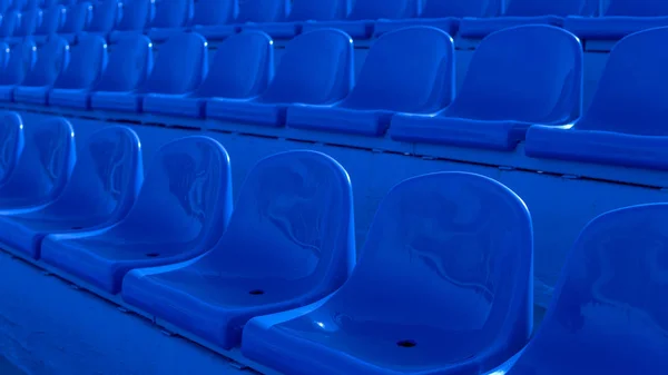 Blanqueadores en un estadio deportivo. Asientos azules en fila — Foto de Stock