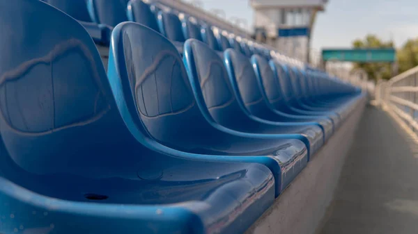 Blanqueadores en un estadio deportivo. Asientos azules en fila — Foto de Stock