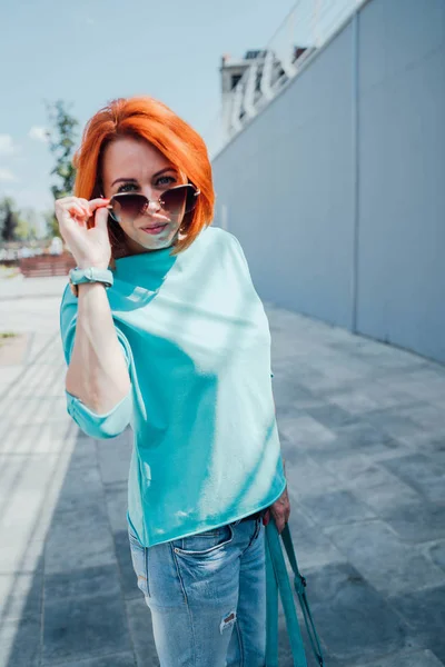 Retrato de jovem ruiva em roupas casuais e com óculos de sol . — Fotografia de Stock