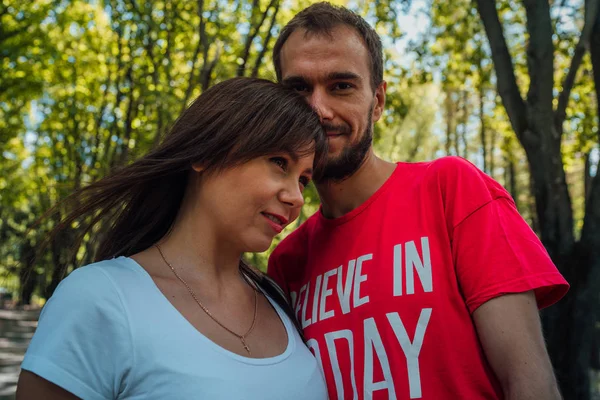 Unga par som älskar att gå genom en park på en solig höstdag, kära människor. Lovers i parken — Stockfoto