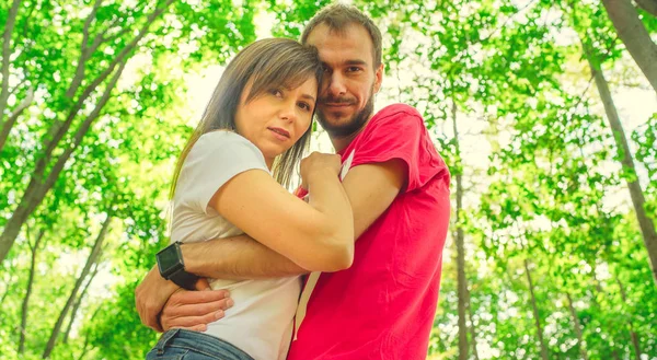 Unga par som älskar att gå genom en park på en solig höstdag, kära människor. Lovers i parken — Stockfoto