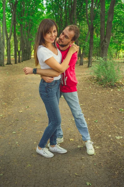 Egy fiatal szerelmespár sétál a parkban egy napsütéses őszi napon, szerelmesek. Szeretők a parkban — Stock Fotó