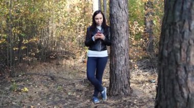 Bahar Ormanı 'nda akıllı telefon kullanan genç bir kadın 