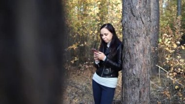 Bahar Ormanı 'nda akıllı telefon kullanan genç bir kadın 