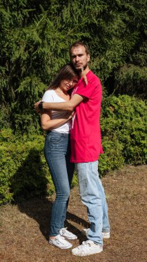 Güneşli bir bahar parkında hamburger yiyen bir kadın. Sunny Day 'li genç bir kadın sonbahar ormanında hamburger yiyor..