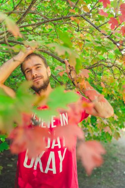 Sonbahar parkında poz veren yakışıklı bir adam..
