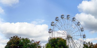 Modern dönme dolap mavi gökyüzüne ve beyaz bulutlara karşı