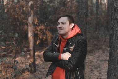 Soğuk akşam ormanında duran yakışıklı adam.