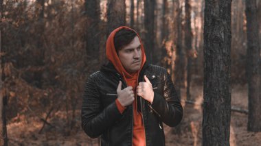 Soğuk akşam ormanında duran yakışıklı adam.