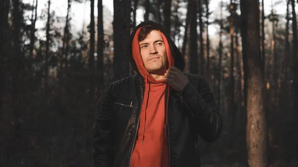 Hombre guapo de pie en el bosque frío de la tarde . — Foto de Stock