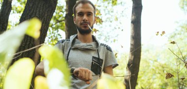 Ormanda sigara içen zayıf bir adam. Hippi parkta sigara içiyor.