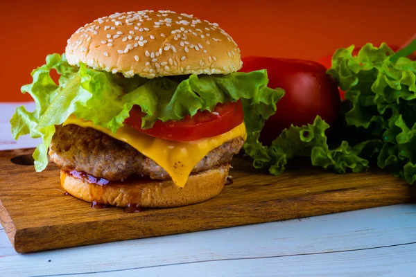 Hambúrguer ou sanduíche. Delicioso hambúrguer sanduíche com carne, queijo e legumes frescos. Hambúrguer ou sanduíche é o popular fast food para brunch ou almoço. Hambúrguer de queijo suculento — Fotografia de Stock