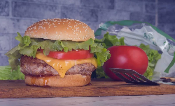 Hamburger oder Sandwich. Köstlicher Sandwich-Hamburger mit Fleisch, Käse und frischem Gemüse. Hamburger oder Sandwich ist das beliebte Fast Food zum Brunch oder Mittagessen. Saftiger Cheeseburger — Stockfoto