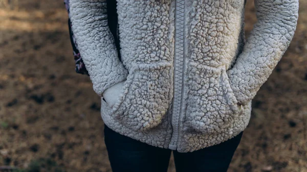 Kobiece ręce w kieszeniach białego puszystego kapturka. Kobieta włożyła ręce do kieszeni, by ogrzać się w zimny jesienny dzień.. — Zdjęcie stockowe